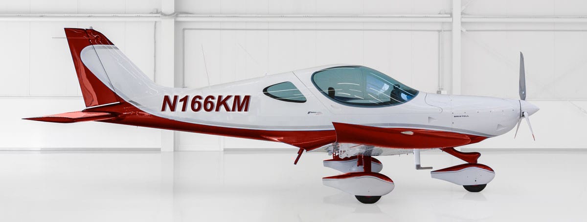 A small red and white plane is parked in the hangar.