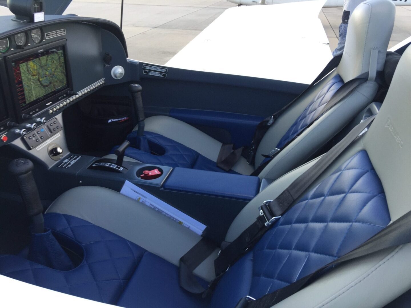 A car seat with two seats and one has a lap top.