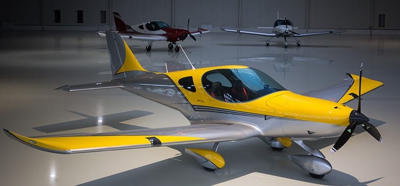 A yellow and silver airplane parked in an airport.