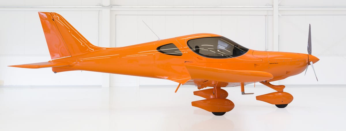 A small orange airplane sitting on top of a white table.