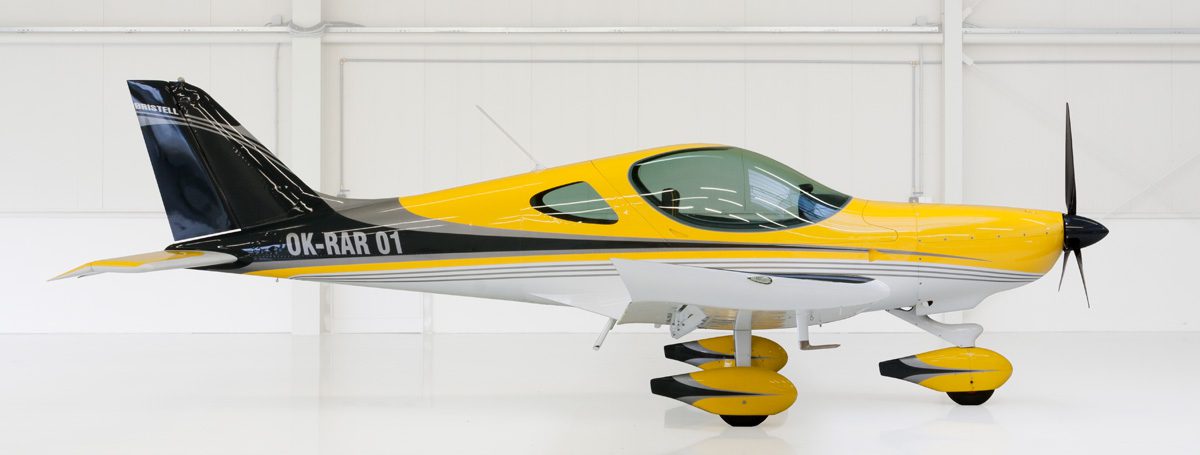 A yellow and black airplane is parked in the hangar.