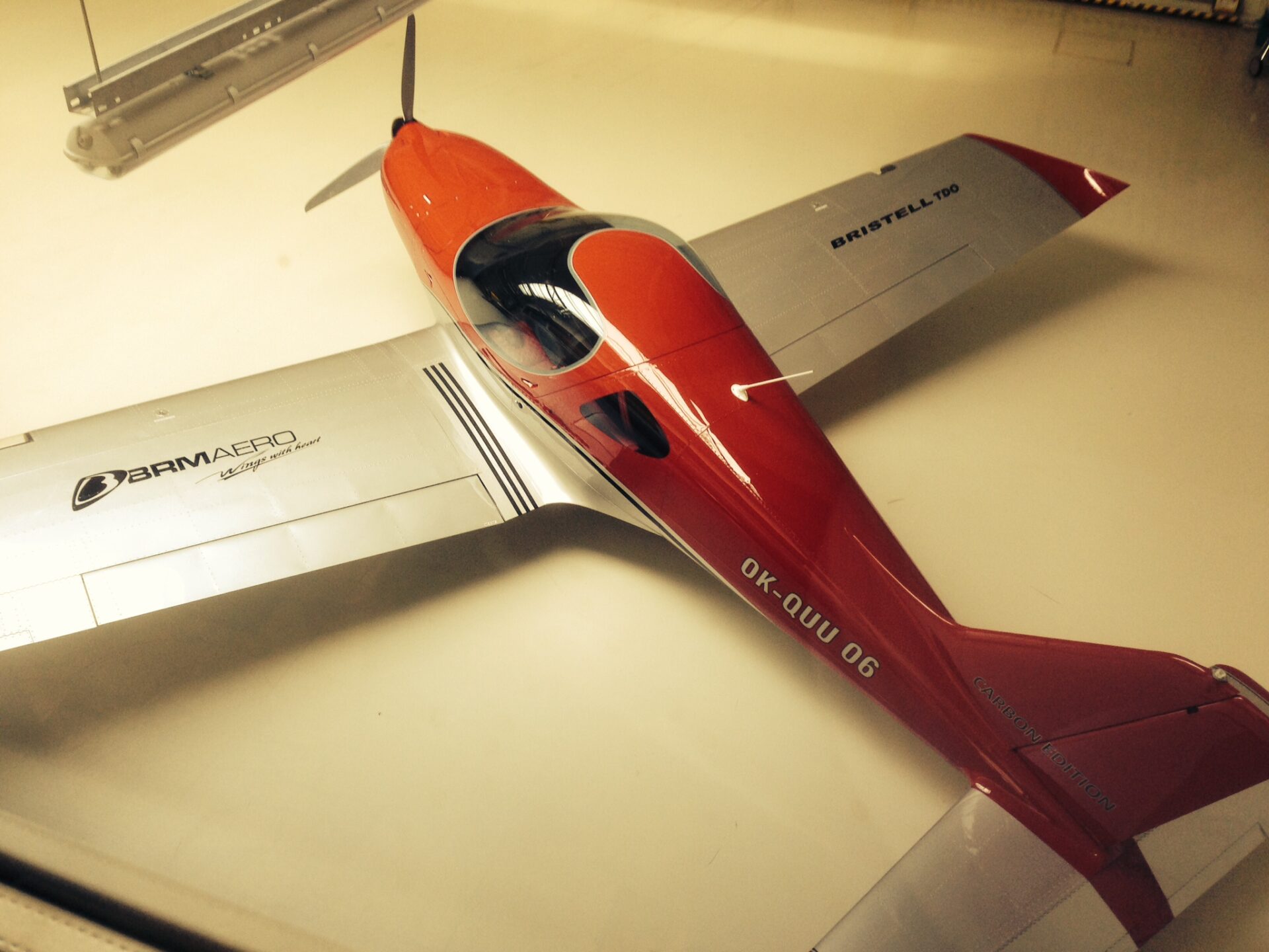 A red and silver airplane is on the table