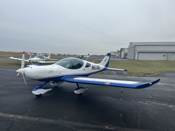 A small white and blue plane sitting on top of an airport runway.